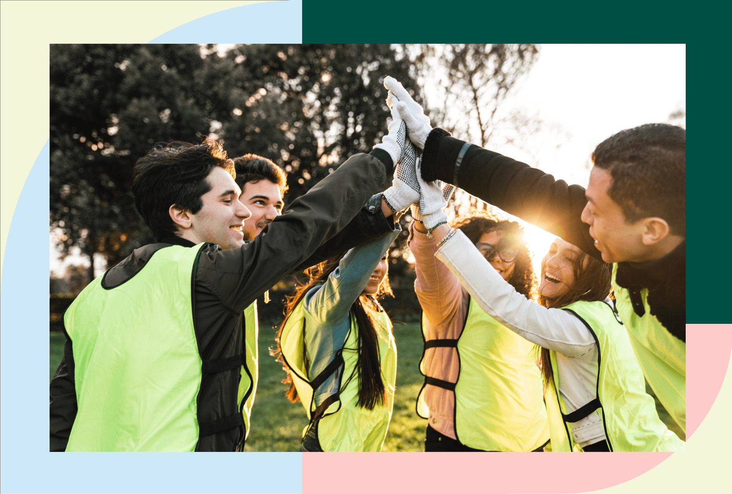 Team in reflective vests raising hands in a group huddle outdoors